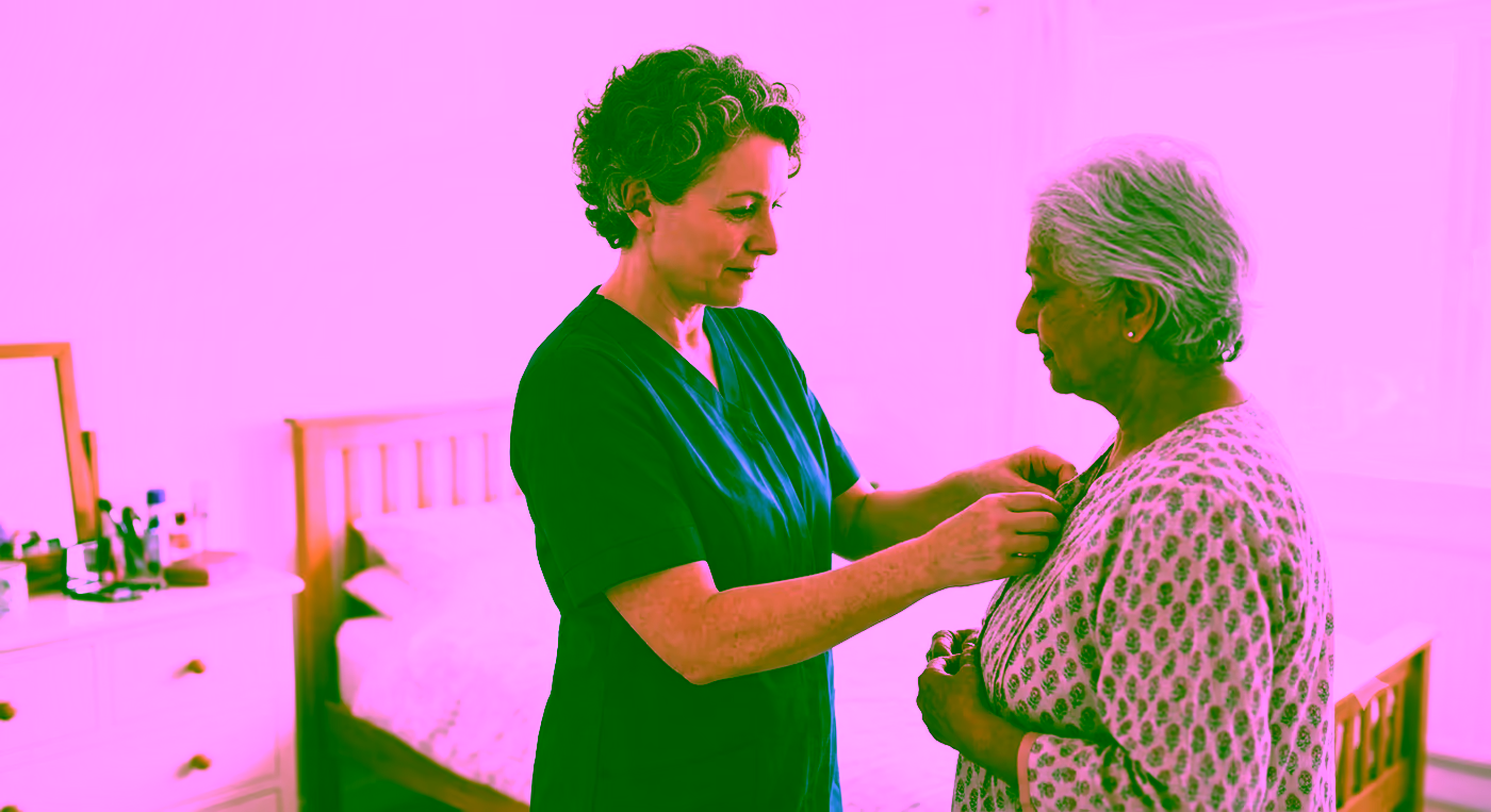 A Dendera Care carer helping an older woman get dressed with care and dignity